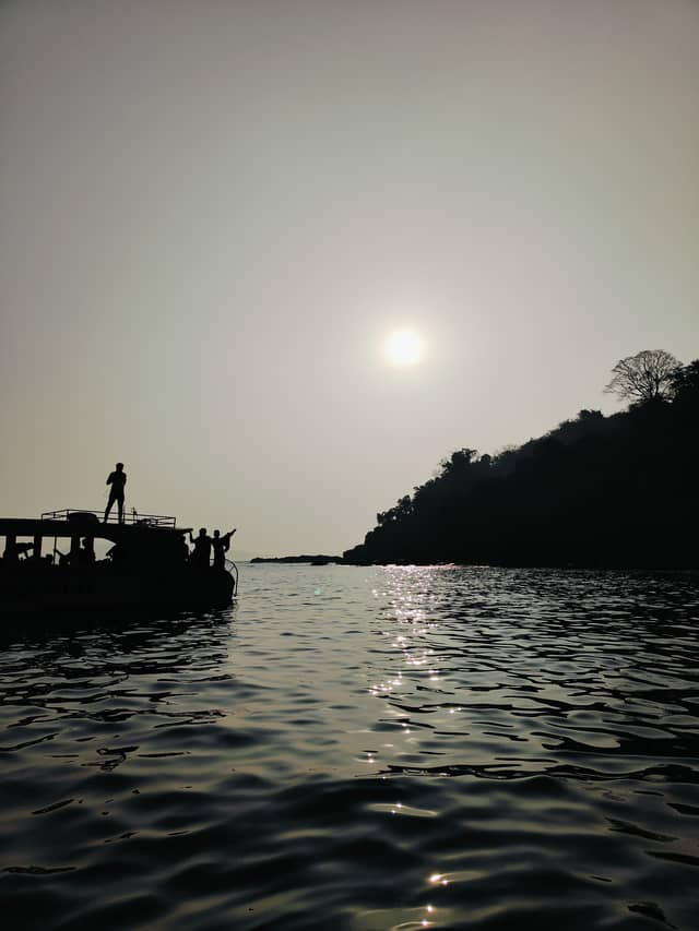 Sunset Boat Silhouette on the Water - Image 1
